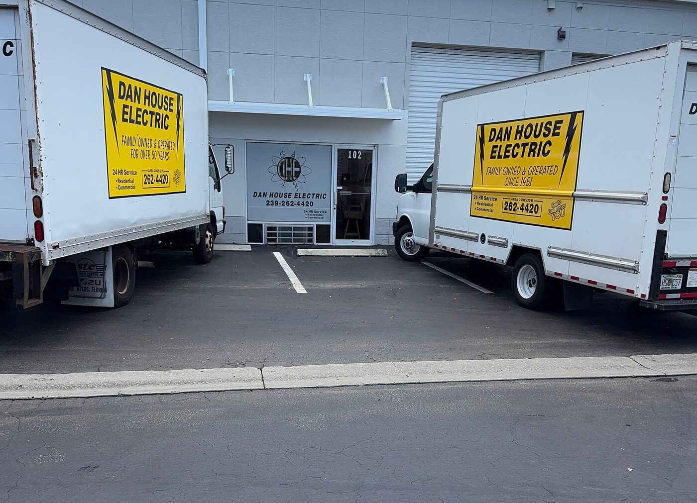 Two Dan House Electric box trucks parked at the company's Naples shop, family-owned since 1951